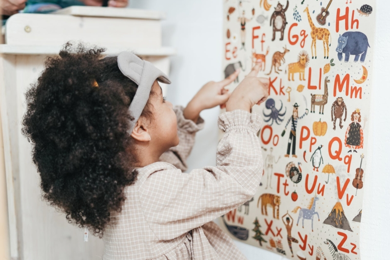 girl pointing on alphabets