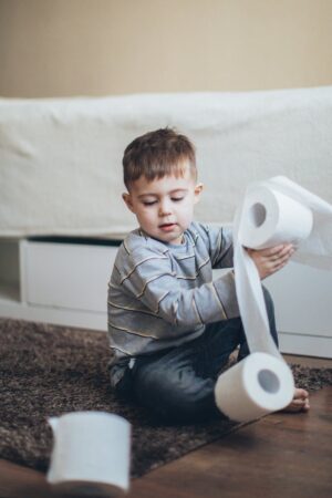 little boy playing with tissue rolls