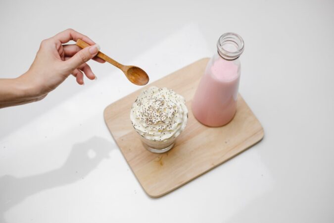 woman checking dessert with whipped cream in studio